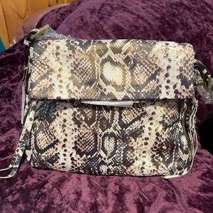 Outside Leather, inside lining is polyester. Measurements 14” wide 11” tall.